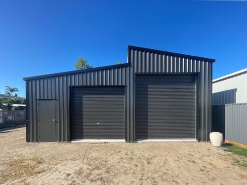 Fully customisable, skillion roof double roll up door with personnel door steel sheds made by Global Sheds using high quality Colorbond Steel and BlueScrop steel to withstand harsh Australian Weather. Built to last.